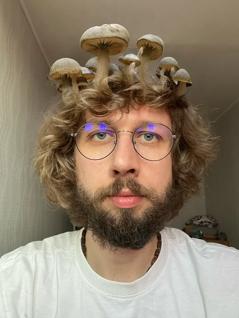 Volodymyr Riabchuk in a playful portrait with mushrooms growing on his head